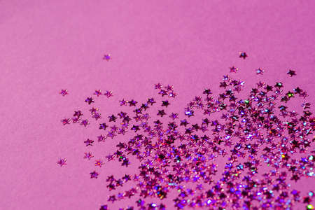 Violet confetti in the form of stars isolated on purple background. Festive day backdrop. Flat lay style with minimalistic design. Template for banner or party invitationの写真素材