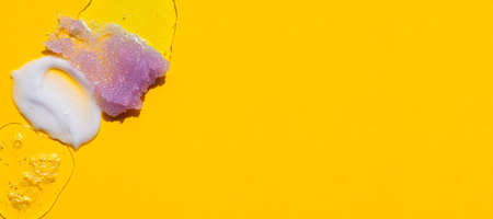 Cosmetic swatches. Appearance of the texture of the cream, oil, serums and sugar body scrub on a yellow background. Natural skincare products. Beauty concept for face and body careの写真素材