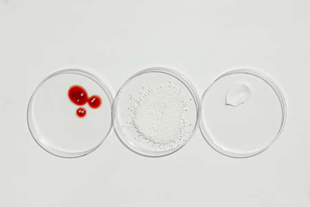 Cosmetic swatches. Appearance of the texture of the cream, red mask and granules in petri dishes on...