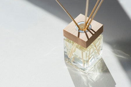 Transparent bottle of aroma diffuser on white background. Eau de parfume for home presentation....