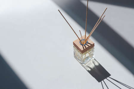 Transparent bottle of aroma diffuser on white background. Eau de parfume for home presentation....