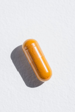 Turmeric plus black pepper extract gelatin capsule close up top view. Herbal supplement organic curcumin. Supports antioxidant healthの写真素材