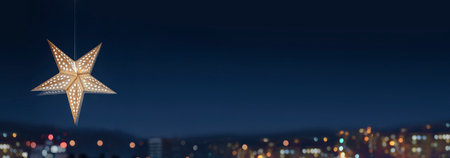 Christmas star-shaped lamp against the backdrop of the night city. Cozy fairytale atmosphere with home decor. Selective focus on star. New Year card with copy spaceの写真素材