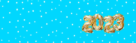 Helium golden balloon number of year 2023. Glowing festive garland with bokeh on blue background. Happy New Year bannerの写真素材