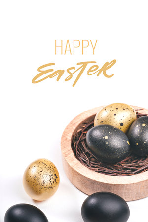 Happy Easter greeting card. Eggs painted black on white background. Nest containing three egg with gypsophila flowers.の写真素材