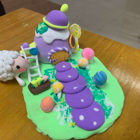 Easter cake decorated with a unicorn and a sheep on a wooden tableの写真素材