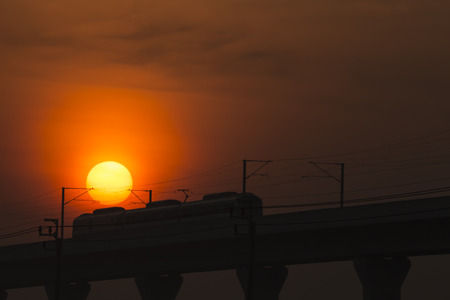 The electric train run pass the sun in twilight time の写真素材
