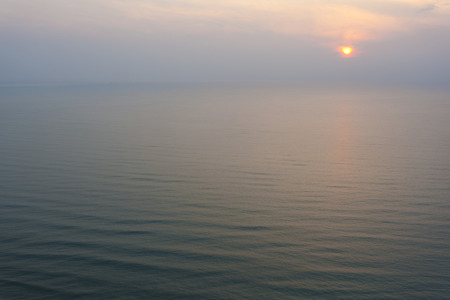 Sunrise scene on the blue vast sea in the foggy day の写真素材
