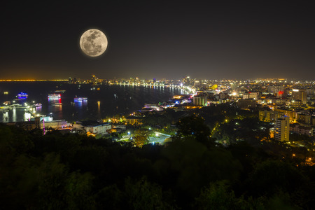 Night view of Pattaya bay with full moon, Thailand の写真素材