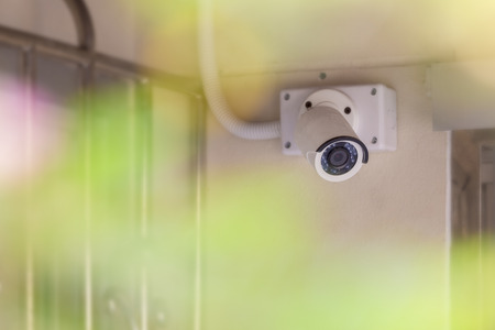 White CCTV mounted on the wall with pipeline.の写真素材