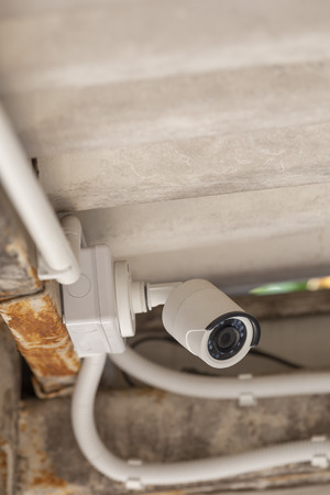 White CCTV mounted under the roof shallow focus.の写真素材
