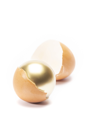 The egg cracked and unviel the golden inside on white background isolatedの写真素材