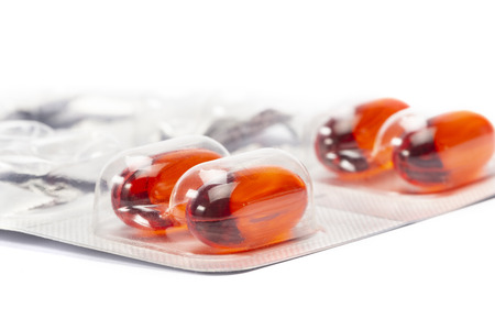 A red tablet medicine in the pcak on white background shallow focusの写真素材