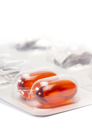 A red translucent pills in tablet on white background shallow focusの写真素材