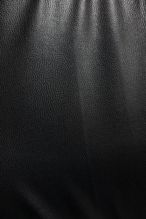 A black leather texture background with highlight from downlightの写真素材