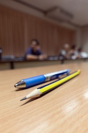 A meeting room with pencil and pen foreground shallow focus portraitの写真素材