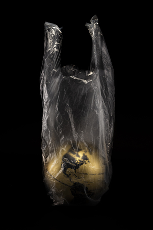 A concept golden earth at America inside transparensy plastic bag isolated on black backgroundの写真素材