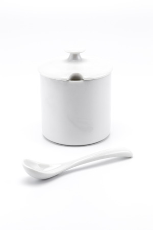 A mini white bowl with spoon outside and close cover in set isolated on white backgroundの写真素材