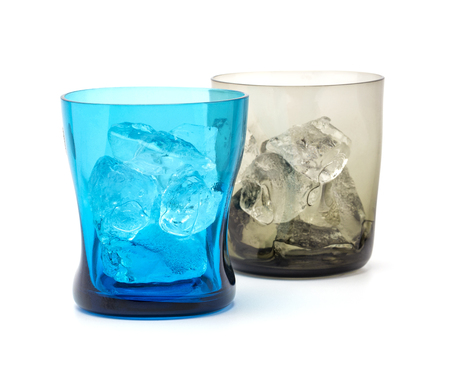 A blue and brown colour modern glass fill with ice isolated on white background shallow focusの写真素材
