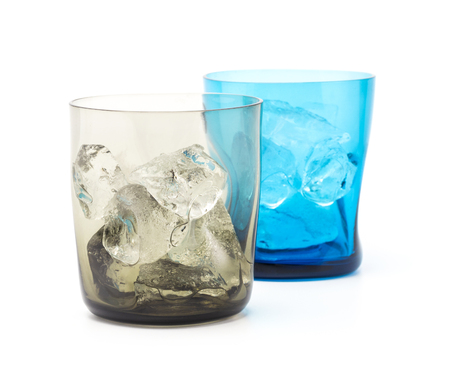 A blrown and blue modern glass fill with ice isolated on white backgroundの写真素材