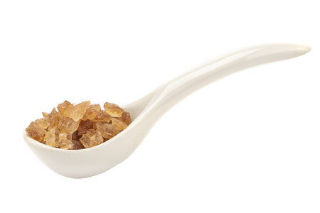 A porcelain spoon with rock sugar inside isolated on white backgroundの写真素材