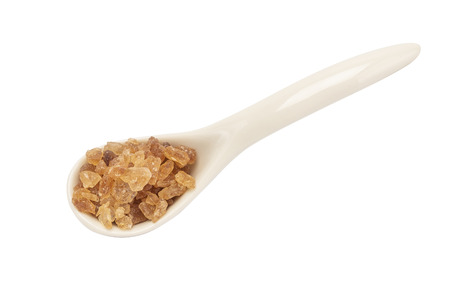 A porcelain spoon with rock sugar inside isolated on white background with clipping pathの写真素材
