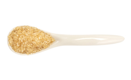 A brown sugar in the ceramic spoon top view with clipping path isolated on white backgroundの写真素材