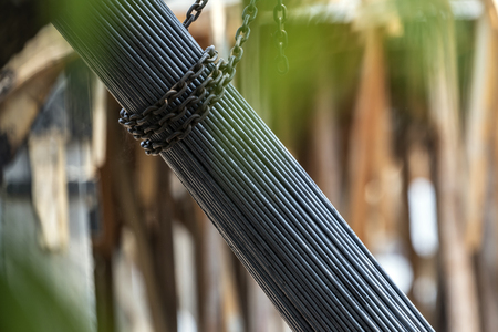 A group of steel rod tight by chain and lift up at construction siteの写真素材