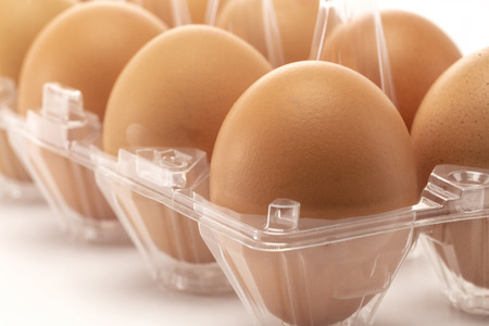 A close-up of eggs in the transparency packaging isolated on white backgroundの写真素材