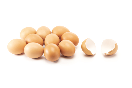 A cracked and open egg beside of other eggs isolated on white backgroundの写真素材