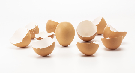 One egg stand up while other has cracked isolated on white backgroundの写真素材