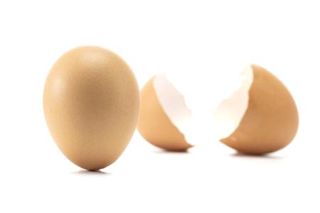 Strong egg stand up and broken egg isolated on white backgroundの写真素材