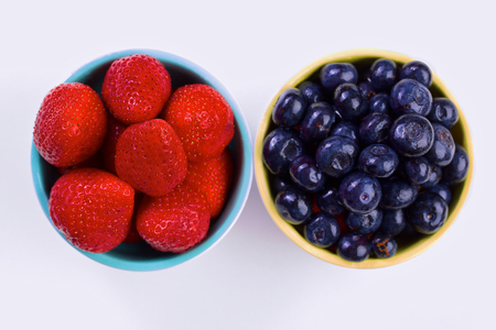 Blueberry and strawberry in white cans on white backgroundの写真素材