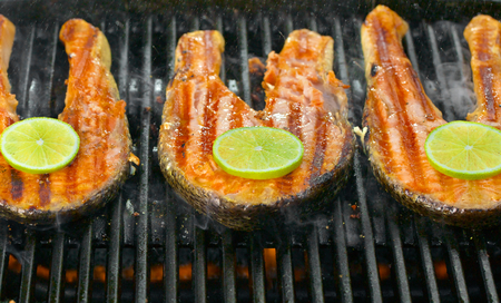 Delicious  portion of fresh salmon fillet with lime cooked on a grill or BBQの写真素材