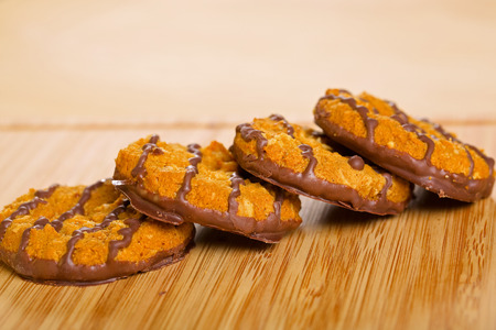 Brown chocolate cookies on wooden table, closeup