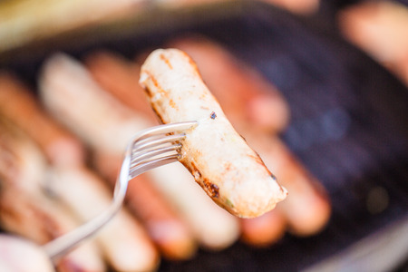 Barbecued beef and pork sausage on forkの写真素材