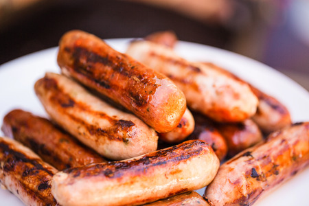 Barbecued beef and pork sausages on white plateの写真素材