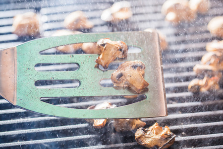 Grilled champignon mushrooms on spatula with steam and drops of waterの写真素材