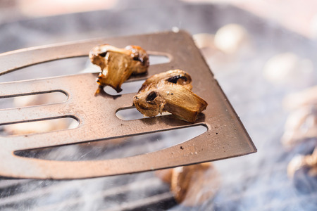 Grilled champignon mushrooms on spatula with steam and drops of waterの写真素材
