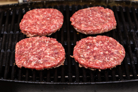 Preparing a batch of grilled ground beef patties on BBQの写真素材