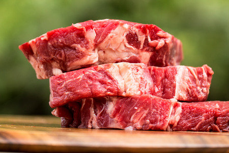 Fresh beef steaks on wooden boardの写真素材