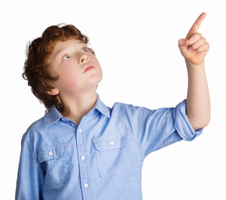 Handsome caucasian boy with red hair points with his finger. Isolated on white backgroundの写真素材