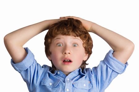 Handsome boy with surprised facial expression putting his hands on his head. Isolated on white backgroundの写真素材