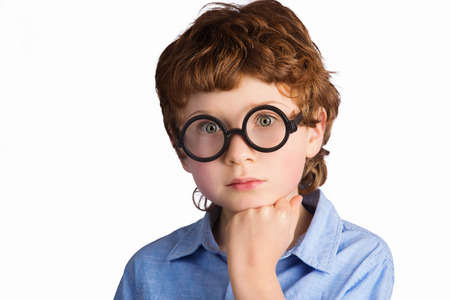 Portrait of handsome thoughtful caucasian boy in round glasses pondering something. Isolated on white backgroundの写真素材