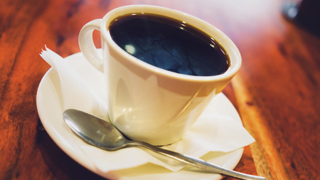 Black coffee in white cup on the brown wooden tableの写真素材