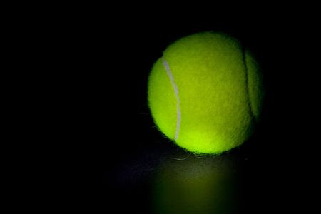Tennis ball on a black backgroundの写真素材