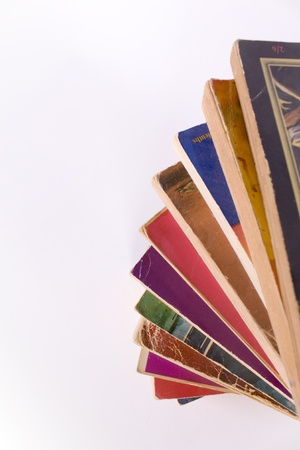 Stack of colorful old paperback books in spiral on white background with space for copyの写真素材