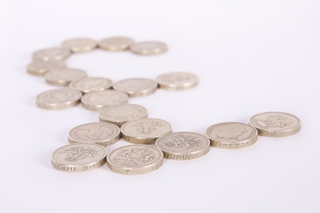 Pound symbol made from gold pound coins on a white background with shallow depth of field.の写真素材