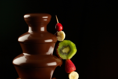 Fruits in chocolate fountainの写真素材