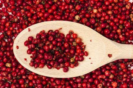 Red Peppercorns and Wooden Spoon Close Upの写真素材